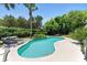 Inviting backyard featuring a kidney-shaped pool surrounded by lush greenery and a lounge area, perfect for relaxation at 2350 Derbyshire Rd, Maitland, FL 32751