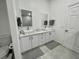 Bright bathroom with dual vanities, large mirrors, and modern fixtures at 2505 Osprey Creek Ct, Kissimmee, FL 34747