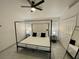 Bedroom with black-framed four-poster bed, tile floor, and ceiling fan at 2505 Osprey Creek Ct, Kissimmee, FL 34747