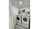 Well-lit laundry room with Samsung washer and dryer on pedestals and shelving at 2505 Osprey Creek Ct, Kissimmee, FL 34747