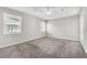 A carpeted bedroom with natural light streaming through two windows and door to patio at 2675 Bond St, Clermont, FL 34711
