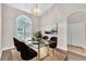 Staged dining room with a modern glass table, chandelier, and a view of a large window with shutters at 2675 Bond St, Clermont, FL 34711