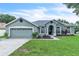 Charming single-story home featuring manicured lawn, two-car garage, and an inviting arched entryway at 2675 Bond St, Clermont, FL 34711