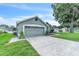 View of the home's side with a two-car garage, concrete driveway, and well-maintained landscaping at 2675 Bond St, Clermont, FL 34711