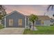 Home exterior featuring gray paint, a palm tree in the front yard and a long driveway at 2936 Estill St, Deltona, FL 32738