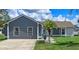 Charming single-story home with gray stucco, white trim, well-maintained lawn, and a welcoming palm tree at 2936 Estill St, Deltona, FL 32738
