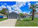 Charming single-story home with a well-manicured lawn, palm trees, and gray and white exterior paint at 2936 Estill St, Deltona, FL 32738