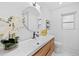 Modern bathroom boasts a stylish wood vanity, sleek fixtures, and a decorative floral arrangement at 3029 Pinetree, Winter Haven, FL 33884