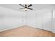 Spacious bedroom with light wood floors, ceiling fan, and large closet with sliding doors at 3029 Pinetree, Winter Haven, FL 33884