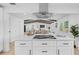 Kitchen island with cooktop and bar seating, flowing into a living area with beamed ceilings at 3029 Pinetree, Winter Haven, FL 33884