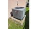 Air conditioning unit on a concrete pad with grass surrounding it at 306 Aylesbury Ct, Kissimmee, FL 34758