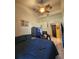 Bedroom with a large blue bed, ceiling fan, tiled flooring, and open doorway at 306 Aylesbury Ct, Kissimmee, FL 34758