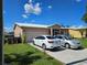 Beige single Gathering house with an attached garage and vehicles in the driveway at 306 Aylesbury Ct, Kissimmee, FL 34758