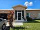 Welcoming front porch with a screen door and manicured landscaping at 306 Aylesbury Ct, Kissimmee, FL 34758