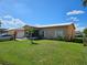 Charming single-story home featuring a well-manicured lawn and lush landscaping at 306 Aylesbury Ct, Kissimmee, FL 34758