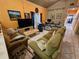 Cozy living room featuring plush green sofas, tiled flooring, and eclectic decor at 306 Aylesbury Ct, Kissimmee, FL 34758