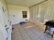 Enclosed patio with neutral tiling, a small window, and access to the back yard at 306 Aylesbury Ct, Kissimmee, FL 34758