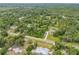 Aerial shot of the property highlighting its location and surrounding landscape with nearby houses and wooded areas at 32125 Okaloosa Trl, Sorrento, FL 32776