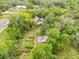 Aerial view of the property showcases the home, outbuildings and garden surrounded by lush greenery and mature trees at 32125 Okaloosa Trl, Sorrento, FL 32776