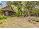 View of the backyard with mature trees, a screened porch, and a wooden shed at 32125 Okaloosa Trl, Sorrento, FL 32776