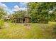 View of the large backyard with a shed and covered work area, perfect for outdoor projects and storage at 32125 Okaloosa Trl, Sorrento, FL 32776