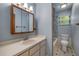 A blue bathroom featuring a shower/tub combo, window, and large mirror at 32125 Okaloosa Trl, Sorrento, FL 32776
