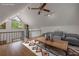 This staged room has vaulted ceilings, railing, wood floors, ceiling fan, and large windows at 32125 Okaloosa Trl, Sorrento, FL 32776