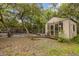 Shed with glass doors and fenced area in a backyard with lush trees at 32125 Okaloosa Trl, Sorrento, FL 32776