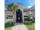 Inviting condo exterior featuring well-maintained landscaping, a palm tree, and walkway to building entrance at 415 Wymore Rd # 101, Altamonte Springs, FL 32714