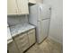 Efficient kitchen layout with a refrigerator and plenty of cabinet space with granite countertops at 415 Wymore Rd # 101, Altamonte Springs, FL 32714