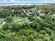 Aerial view of home nestled in a treed lot with nearby lake and residential community at 4925 Catfish Rd, Lake Wales, FL 33898