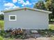 Back exterior of home with a small window and a pile of logs near the gray wall at 4925 Catfish Rd, Lake Wales, FL 33898