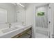 Modern bathroom features double sinks with white marble counters and bright natural light from the shower at 523 Sanctuary Golf Pl, Apopka, FL 32712