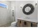 Modern bathroom with walk-in shower, decorative mirror, and stylish vanity with a light countertop at 523 Sanctuary Golf Pl, Apopka, FL 32712