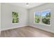 Bedroom featuring hardwood floors and dual windows offering natural light and outdoor views at 523 Sanctuary Golf Pl, Apopka, FL 32712