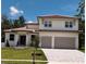 Charming two-story home with a tile roof, green lawn, two-car garage, and blue door at 523 Sanctuary Golf Pl, Apopka, FL 32712