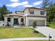 Beautiful two-story home featuring a landscaped front yard, a neutral color palette, and a two-car garage at 523 Sanctuary Golf Pl, Apopka, FL 32712