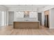 Bright kitchen with stainless steel appliances, a center island, pendant lighting, and wood-look flooring at 523 Sanctuary Golf Pl, Apopka, FL 32712