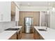 Contemporary kitchen with a stainless steel refrigerator, white countertops, and modern cabinets with gold hardware at 523 Sanctuary Golf Pl, Apopka, FL 32712