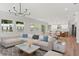 Bright, open living space features hardwood floors, large windows, and a stylish sectional sofa at 523 Sanctuary Golf Pl, Apopka, FL 32712