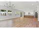 Spacious living room with wood floors, recessed lighting, a modern chandelier, and a view of the backyard at 523 Sanctuary Golf Pl, Apopka, FL 32712