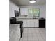 Another view of the functional kitchen with white cabinets, stainless steel appliances, granite countertops and tile flooring at 5396 Lonesome Dove Dr, Kissimmee, FL 34746