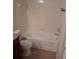 Clean bathroom with a tub, tile surround, and neutral floor tile at 5725 Gatlin Ave # 315, Orlando, FL 32822