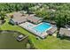 Aerial view of the community pool with tennis courts, a lakefront view, and a dock at 616 Woodridge Dr, Casselberry, FL 32730