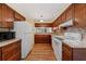 Well-lit kitchen featuring wood cabinets, and white appliances at 616 Woodridge Dr, Casselberry, FL 32730