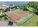 Aerial view of the community tennis courts by the lake with lush trees at 616 Woodridge Dr, Casselberry, FL 32730