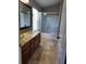 Bathroom featuring glass bowl sinks, stone floors, and a shower-tub combination at 6416 S Goldenrod Rd # 8A, Orlando, FL 32822
