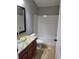 A bathroom features granite countertop, glass sink, and tub with shower at 6416 S Goldenrod Rd # 8A, Orlando, FL 32822