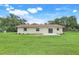 Expansive backyard features lush green grass, mature trees, and a patio at 6720 Midland Drive, St Cloud, FL 34771