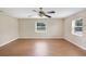 Bright bedroom features wood-look flooring, neutral walls, two windows and a ceiling fan at 6720 Midland Drive, St Cloud, FL 34771